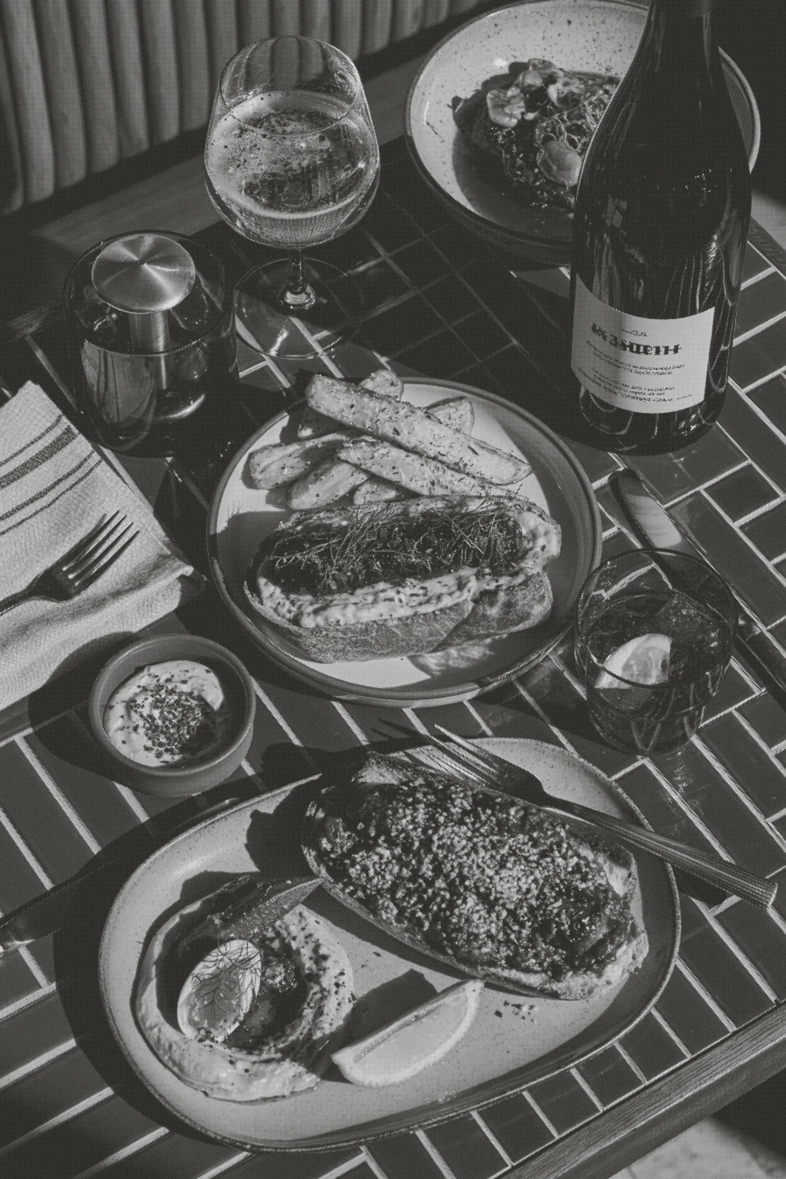A pub lunch spread across the green-tiled table with a bottle of white.